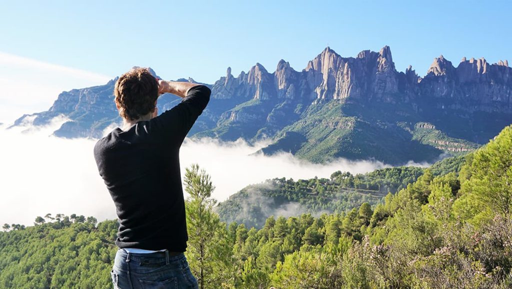 Man taking a picture of Montserrat mountain range near Barcelona.