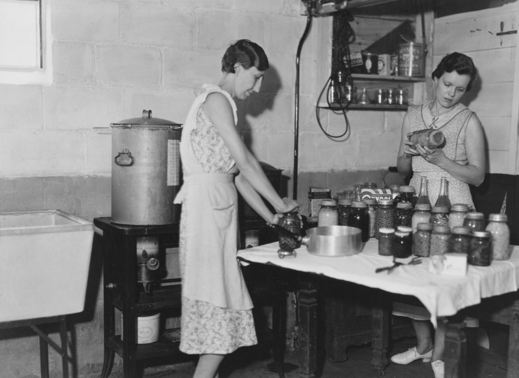 Old picture onf two women at an industrial kitchen.