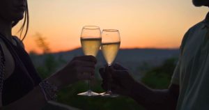 Couple toasting with sparkling Cava at Montjuic at sunset during a Barcelona Sidecar Tour experience.