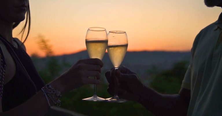 Couple toasting with sparkling Cava at Montjuic at sunset during a Barcelona Sidecar Tour experience.