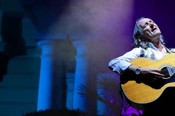 singer on a stage playing passionally his guitar