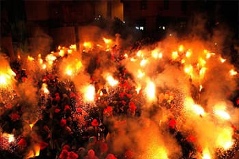 crowd holding torches in a spanish square