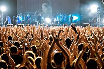 Massive crowd cheering in front of music stage with band playing for primaver sound in barcelona.