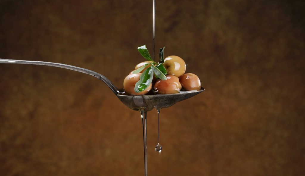 Spoon with olives and olive oil from Spain.