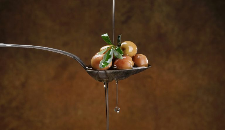 Spoon with olives and olive oil from Spain.